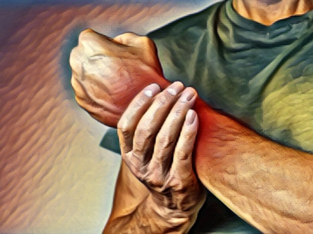 Man suffering from wrist pain and holding painful hand with red spot closeup