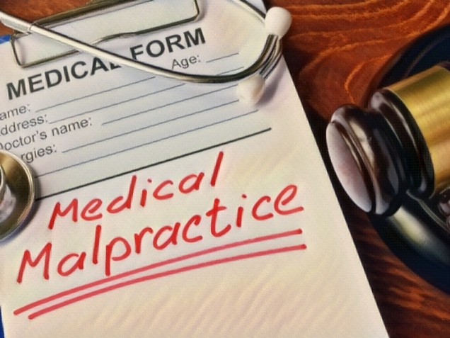 Medical form with words Medical Malpractice and gavel