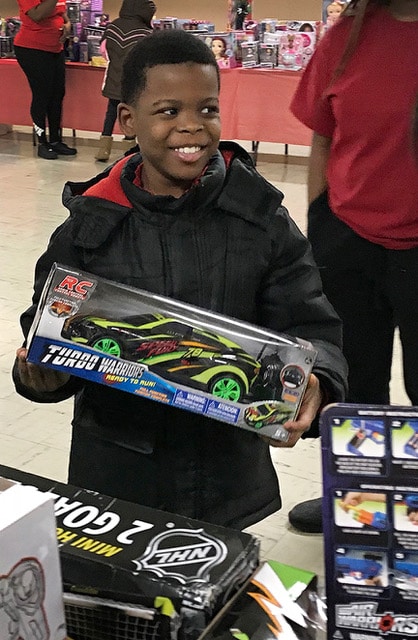 Happy kid holding the toy remote car he received at the Ankin Law Toy Drive