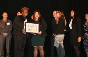 A smiling Jocely Pacheco receiving the Public Interest Advocate Scholarship Award