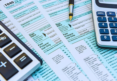 U.S. tax forms, specifically IRS Form 1040, alongside a calculator and a pen.