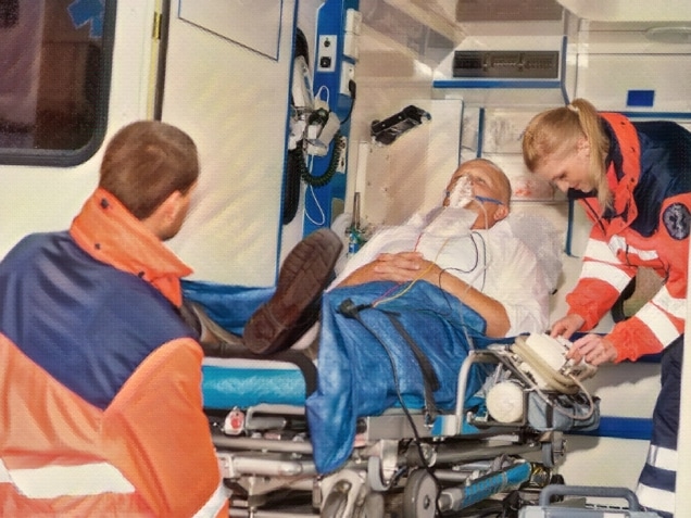 Paramedics putting patient man oxygen mask in ambulance car. Concept of Paramedics putting patient man oxygen mask in ambulance car