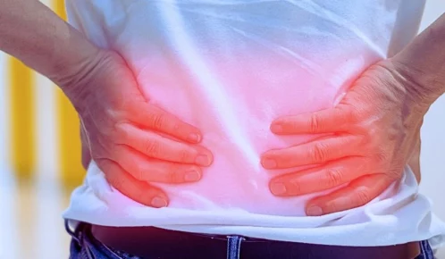 Man's hands on his back with red spot as suffering on backache.