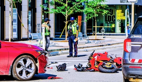 Motorcycle hit by car on Toronto street during summer day. Police car on the site too. motorcycle injury claim