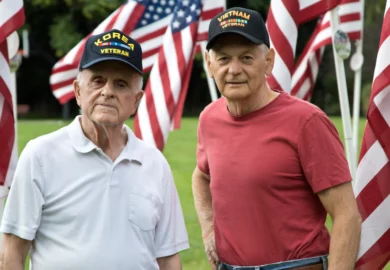 Korean and Vietnam veterans with disability claims stand in front of US flags.