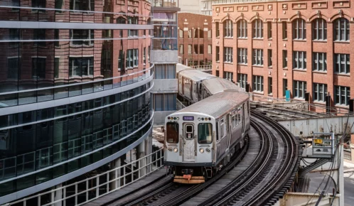 Chicago typical silver colored commuter train moving on elevated tracks to railroad