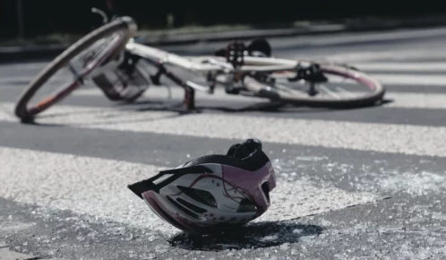 A helmet and a bicycle lying on the ground.