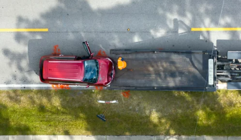 Red car being towed after a collision.
