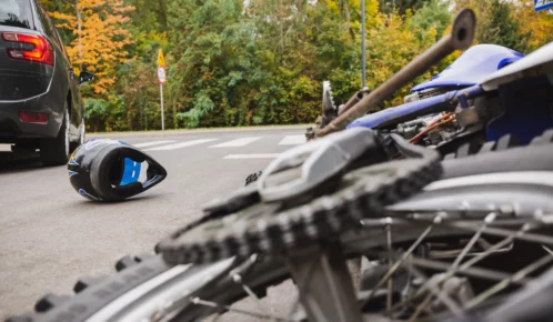Motorcycle lying on the street after being hit by a car.