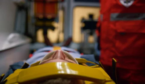 Injured man on a stretcher inside an ambulance.