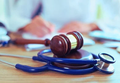 Close-up of judge hammer and doctor stethoscope on office desk. Compensation for Medical Malpractice Victims