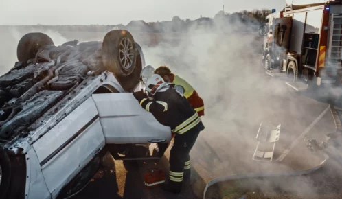 Paramedics working to extract an injured passenger from a fatal car accident.