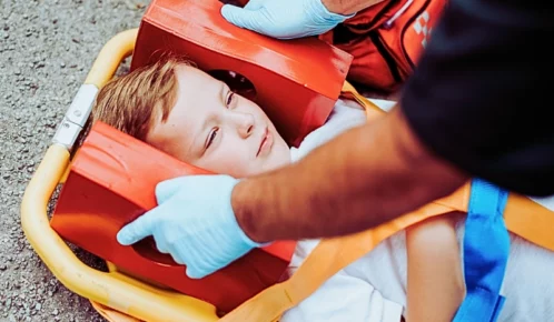Young injured boy lying on an ambulance stretcher. hurt at daycare