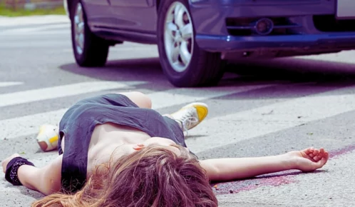 Woman lying on the ground after hit by a car. pedestrian deaths
