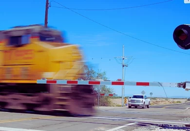 A speed blur of a locomotive passing through a railroad crossing.