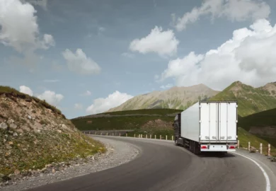 semi truck driving on a curve lane.