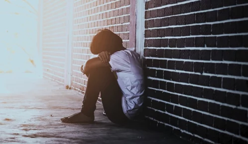 Sad boy hiding at school after abuse.