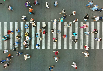 Overhead view of a crowded pedestrian crosswalk with people walking in different directions.