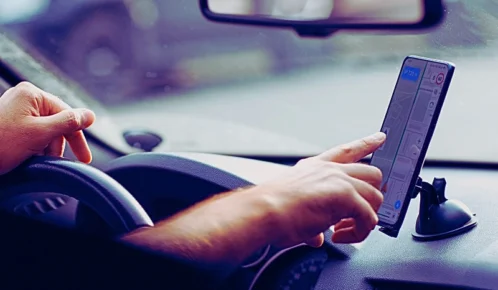 Driver man using mobile phone navigator app. Car Accidents Caused by GPS