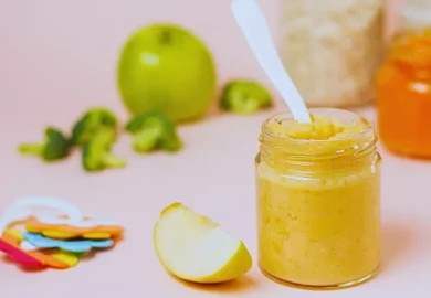 Baby food jar, fruits and baby rattle