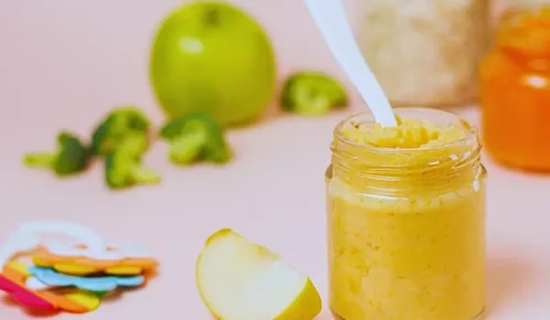 Baby food jar, fruits and baby rattle