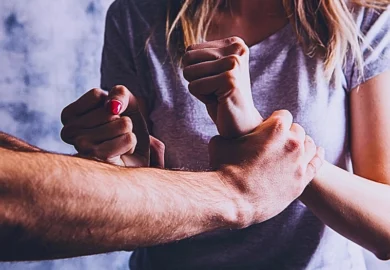 Abusive husband holding his wife's wrists. Criminal Charges and Civil Claims for Sexual Assault