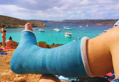 Man's foot on cast sitting by the beach. Tourist Injuries in Chicago