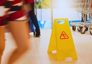 A yellow caution sign on a tiled floor inside a store, warning of a slippery surface. Actual vs. Constructive Notice