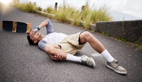 Injured man using skateboard.