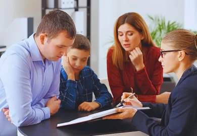 four people sitting around a table engaged in a discussion.