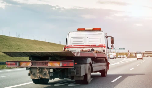 Empty flatbed tow carrier truck empty car carrier and flatbed tow truck vehicle travelling on a national road.