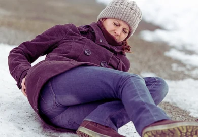 Woman experiencing back ache after she got slip on an icy road.
