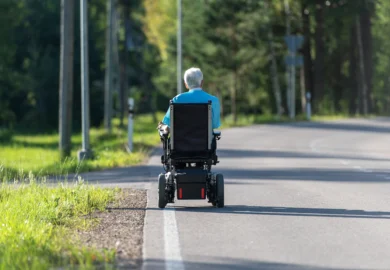 Elderly man using a black mobility scooter.