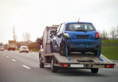 Tow truck with a wrecked blue car.