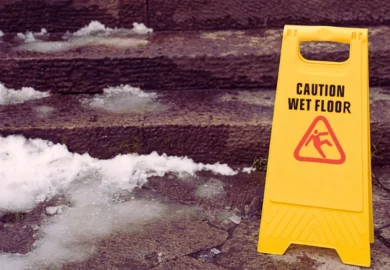 Yellow "Caution Wet Floor" sign on icy steps. How Long Does a Property Owner Have to Fix a Hazard