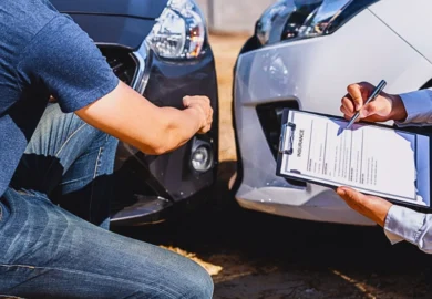 Man inspecting car damage while agent fills insurance form. Insurance Company Delaying My Car Accident Claim