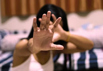 Woman holding her hand up to block her face. Airbnb Sexual Assault Lawsuits