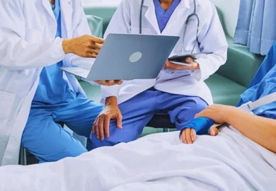 Two doctors showing a laptop to a hospital patient. doctor's notes hurt your car accident claim