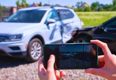 Person taking a smartphone photo of a car accident. evidence conflicts after a Chicago car accident