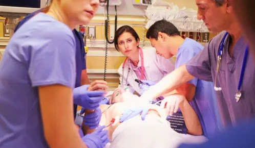 Healthcare worker comforting her exhausted colleague on hospital floor. inadequate staff training