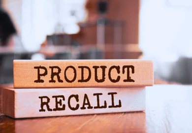 Wooden blocks with "PRODUCT RECALL" text on table.