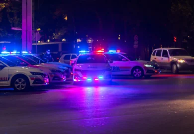 Multiple police cars with flashing emergency lights parked at night.