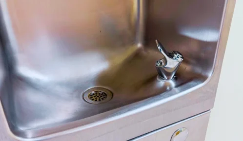 Close-up view of a clean stainless steel drinking fountain basin.