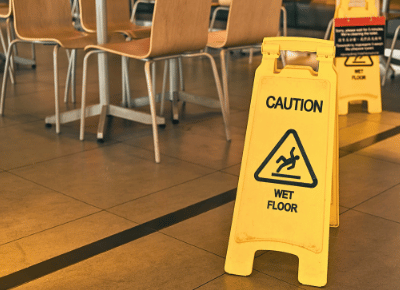 A yellow "wet floor" caution sign in a commercial space.